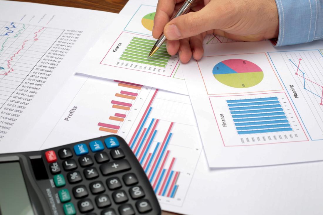 Financial charts and a calculator on a desk